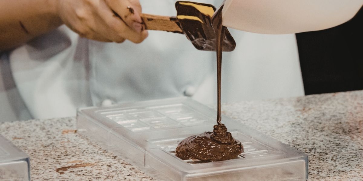 Fabrication artisanale de chocolats personnalisés sur mesure, moulage en atelier O'BomB